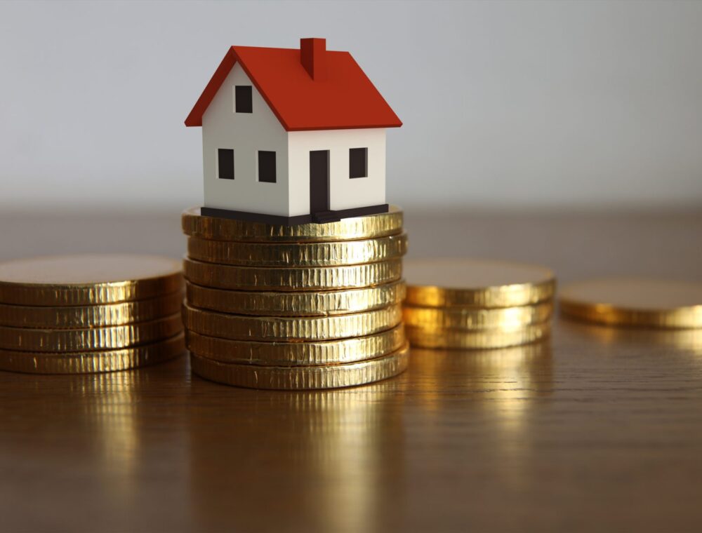 house sits on coins showing saving money using a property buying agent saving you money