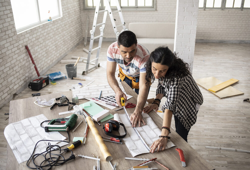 Couple making home improvement and measuring.